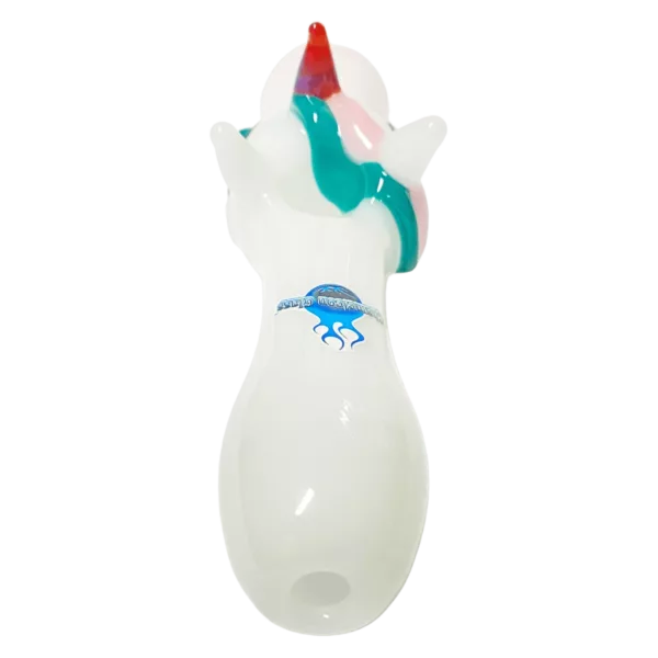White plastic toy or decorative item with blue, green, and red design. Sitting on green surface.
