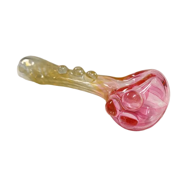 Handcrafted pink & gold glass pipe with a small spoon bowl, sits on a green surface.