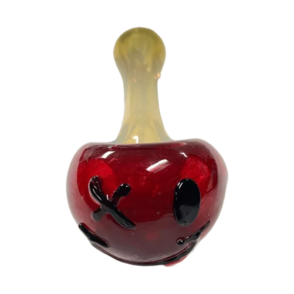 playful glass pipe with a clown-themed mouthpiece and a round bowl. It has an orange stem and clear base. The design is cheerful and colorful.