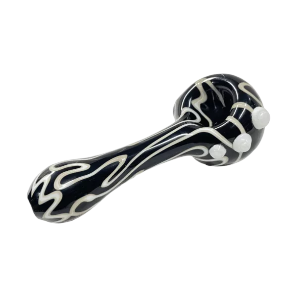 Glass pipe with black and white swirls and a small white dot on the end, made by Wayne Wagoner. It has a curved shape and is sitting on a green background.