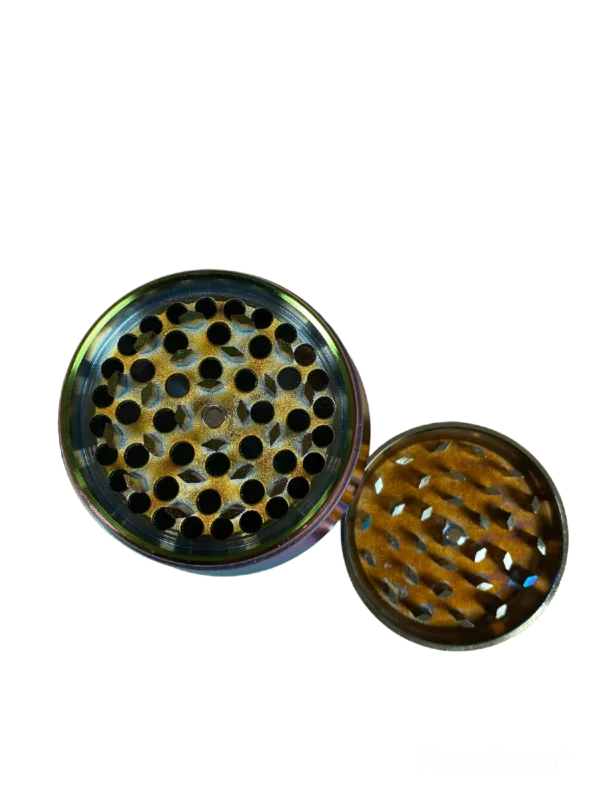 Image of circular metal grinder with golden color, black rim, and small center hole on green background.