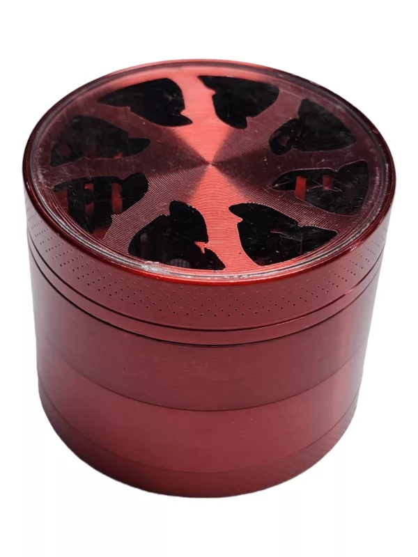 Circular red metal grinder with black handle and small center hole.