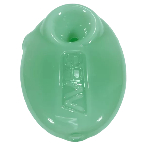 A close-up image of a green glass spoon with a clear, smooth surface and a curved bowl. It is lightweight and sits on a green background.
