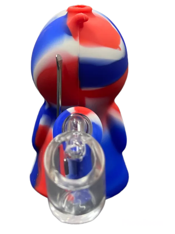 Plastic ghost figurine with blue, red, and white body, sitting on a transparent base inside a glass vial.