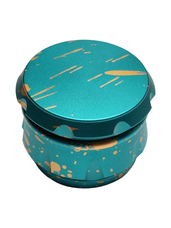 A small, blue and gold grinder with a matte finish and small hole on side. Smooth top and spiked bottom.
