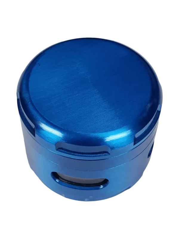 A blue metal container with a smooth surface and a lid, containing the Zinc Window Grinder - BVGS077, sits on a green background.