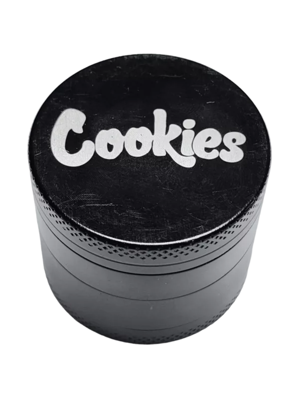 Round metal grinder with 'cookies' written in white on a green background.