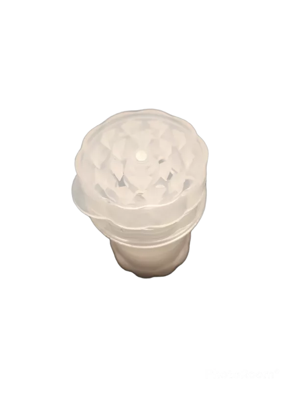 Plastic Bottle Grinder 4 Part WW207 with transparent container and lid, white pattern, and small hole in center. Container sits on green background.